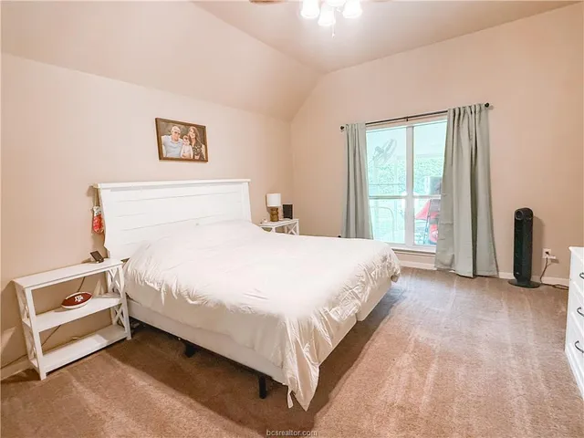 a large bed sitting in a bedroom next to a window