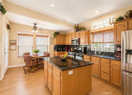 a kitchen with stainless steel appliances granite countertop sink stove and table