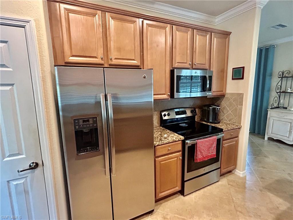 9511 Napoli Lane, Unit 202 Naples, FL 34113 - Photo 14 of 50 a kitchen with granite countertop a stove and a refrigerator