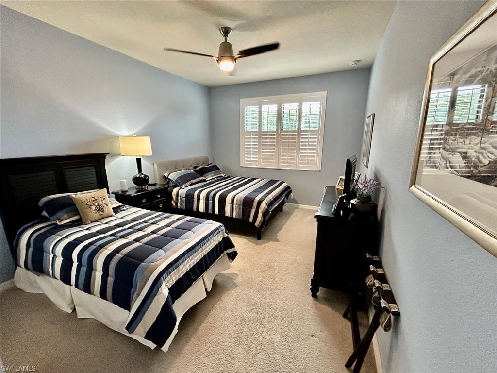 9511 Napoli Lane, Unit 202 Naples, FL 34113 - Photo 31 of 50 a bedroom with three beds and a window