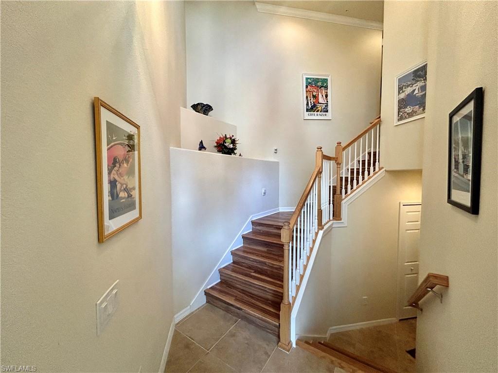 9511 Napoli Lane, Unit 202 Naples, FL 34113 - Photo 6 of 50 a view of staircase with lots of frames on wall and a window