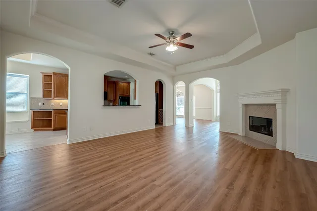 a view of a livingroom with wooden floor and a fireplace