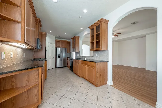 a large kitchen with stainless steel appliances granite countertop a stove a sink and a refrigerator