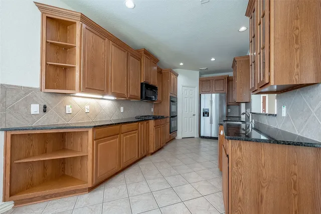 a kitchen with stainless steel appliances granite countertop a stove a sink and a microwave