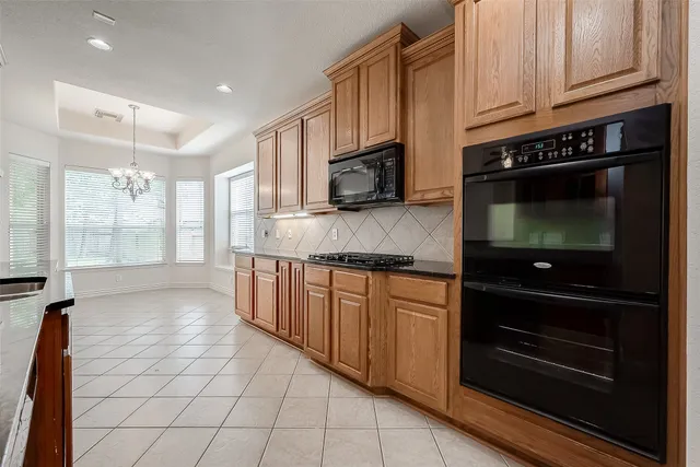 a kitchen with stainless steel appliances granite countertop a stove a microwave and a sink