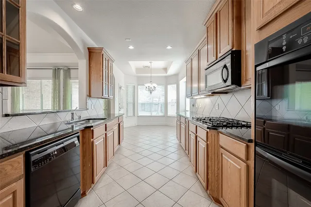 a kitchen with stainless steel appliances granite countertop a stove a sink and a refrigerator