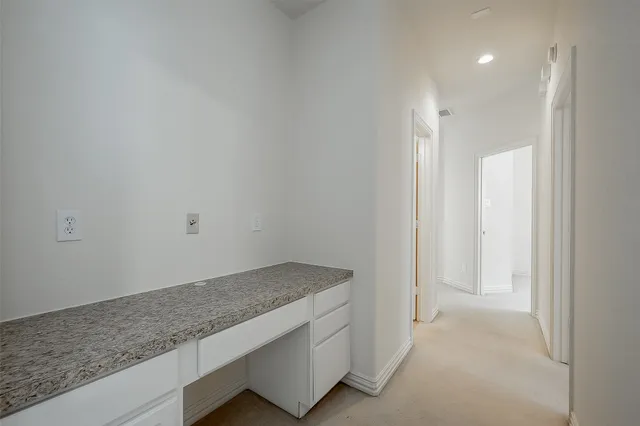 a bathroom with a granite countertop sink and white cabinets