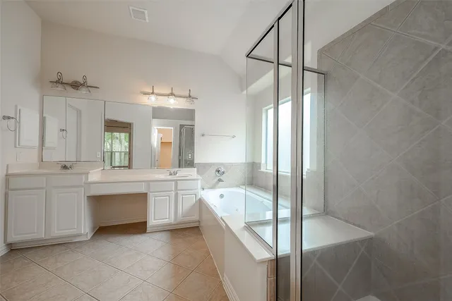a large white bathroom with a large tub sink vanity and granite