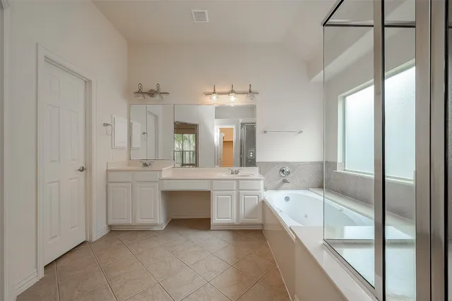 a large bathroom with a large tub sink shower and view living room