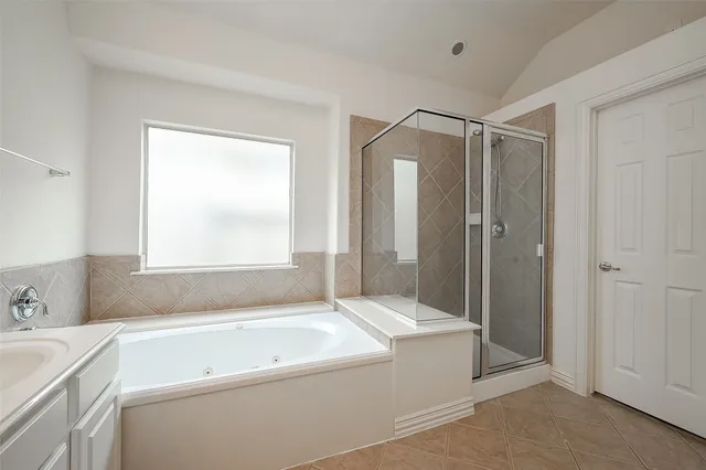 a bathroom with a tub a sink and a window