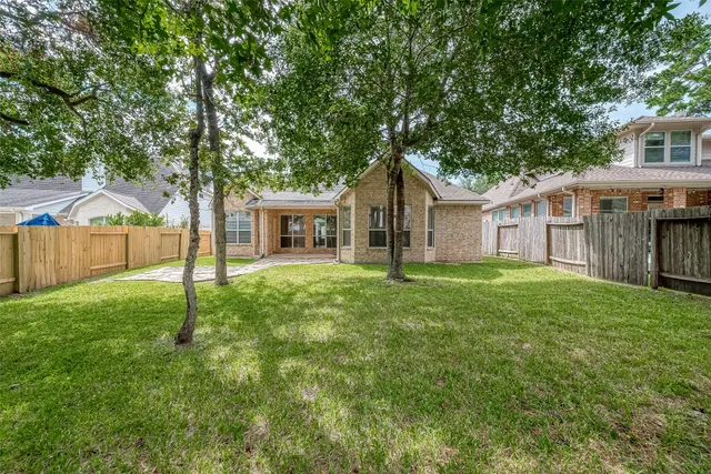 a front view of a house with yard and tree