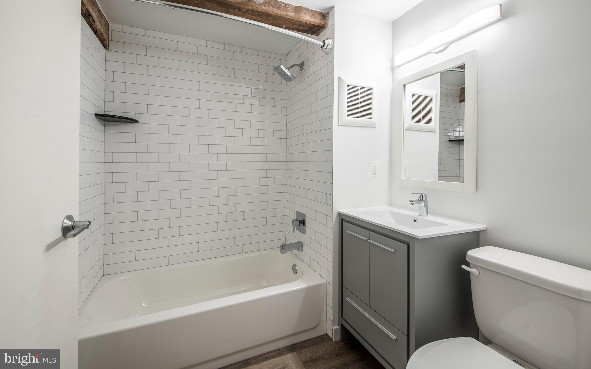 1201 Jackson Street, Unit 554 Philadelphia, PA 19148 - Photo 37 of 42 a bathroom with a sink a toilet and shower