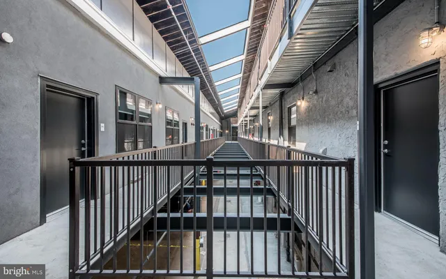 a view of staircase with lots of frames on wall and a large window