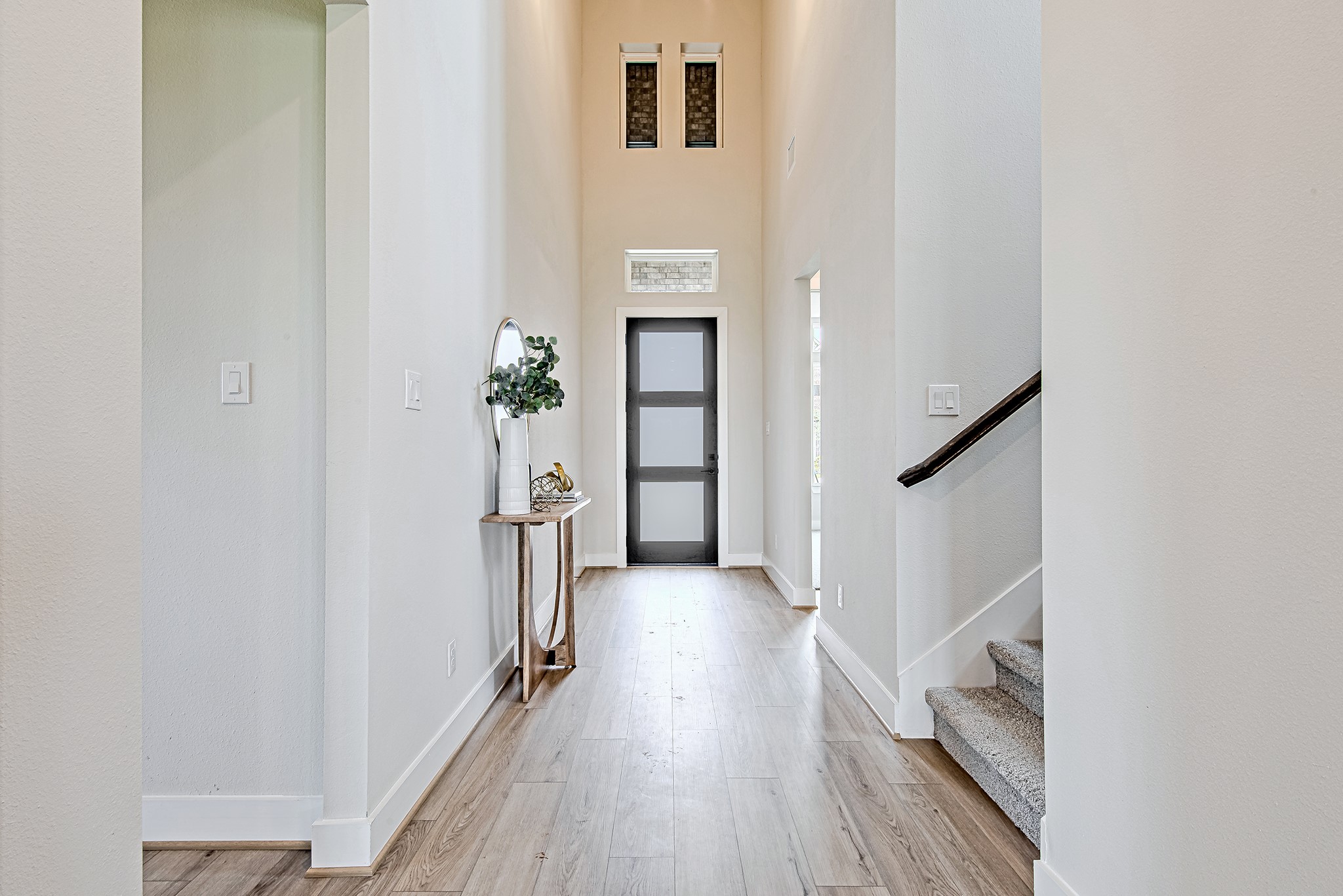 141 Peninsula Point Drive Montgomery, TX 77356 - Photo 8 of 47 A dramatic foyer welcomes you with sky-high ceilings, transom windows, and natural light that pours in through the frosted glass front door—with the staircase to the second floor thoughtfully positioned just to the right.