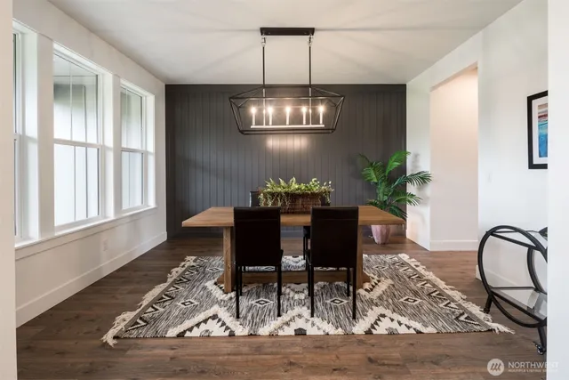 a view of a dining room with furniture a chandelier and wooden floor