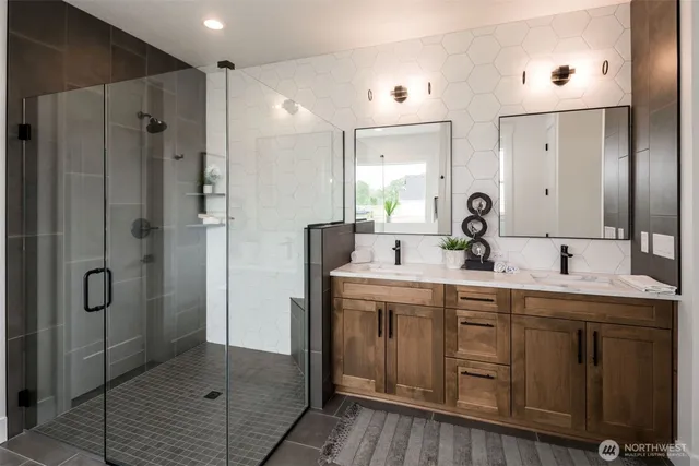 a bathroom with a double vanity sink mirror and shower