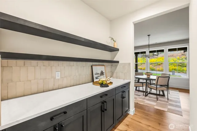 a kitchen with a sink a counter and chairs in it