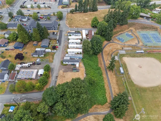 an aerial view of residential houses with outdoor space and parking