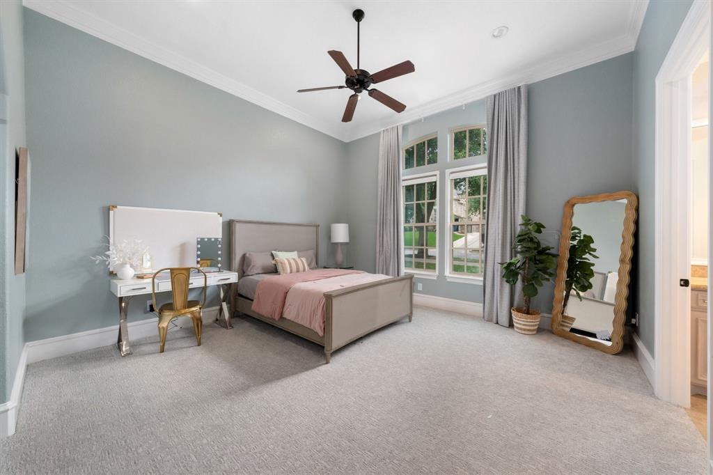 2101 Vail Road Southlake, TX 76092 - Photo 25 of 40 a spacious bedroom with a bed and a chandelier