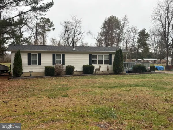 a front view of house with yard and trees around