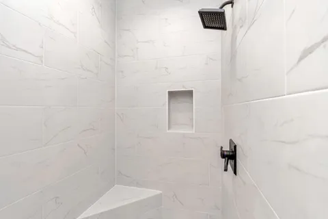a spacious bathroom with a granite countertop sink mirror and a bathtub