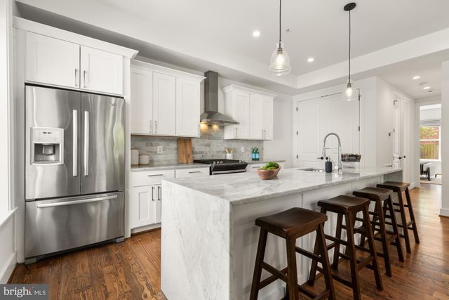 a kitchen with refrigerator cabinets and wooden floor
