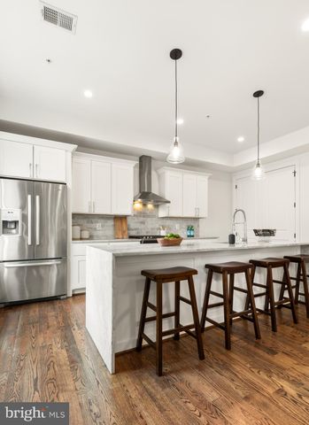 a kitchen with stainless steel appliances granite countertop a table chairs sink and cabinets