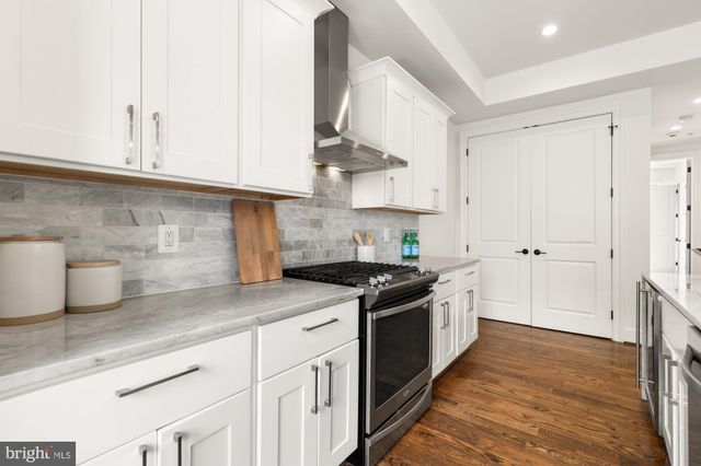 a kitchen with stainless steel appliances granite countertop a sink and a stove