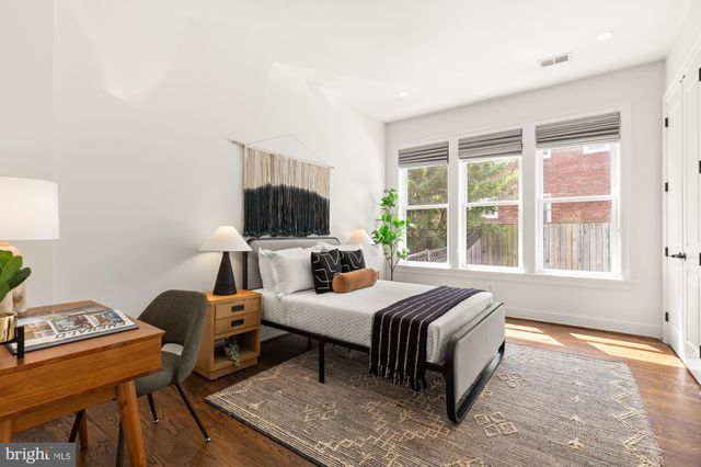 a bedroom with a bed and large windows