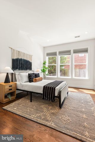 a spacious bedroom with a bed and wooden floor