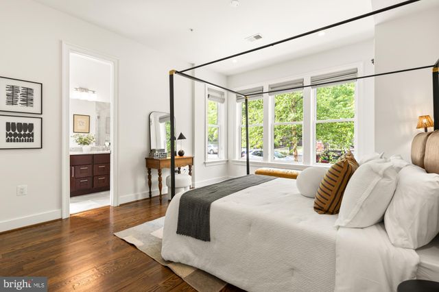 a bedroom with a bed couches and wooden floor
