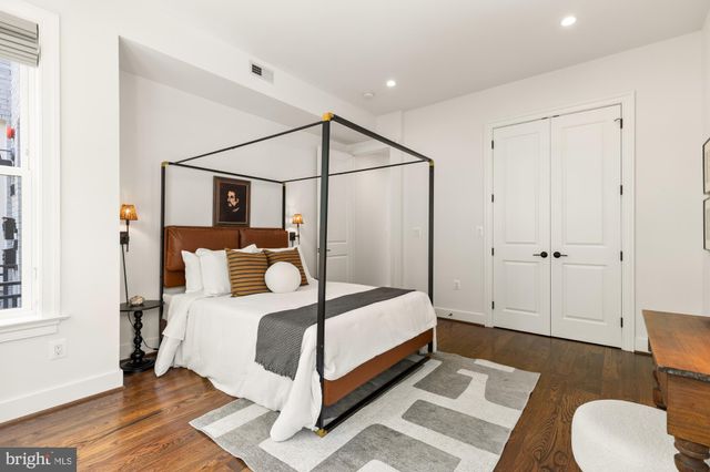 a bedroom with a bed lamp closet and window