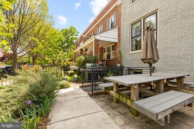 a view of house with patio outdoor seating and covered with trees