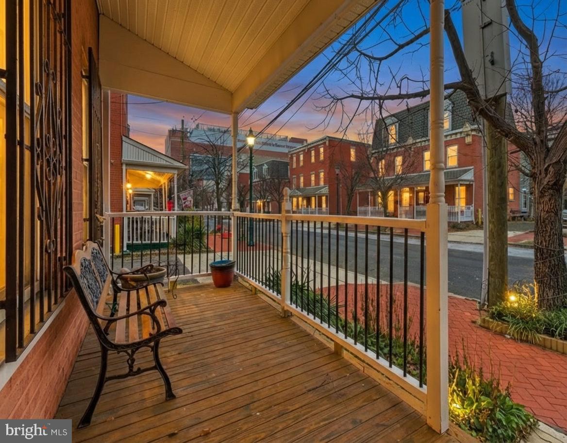 a view of a balcony with two chairs and wooden floor