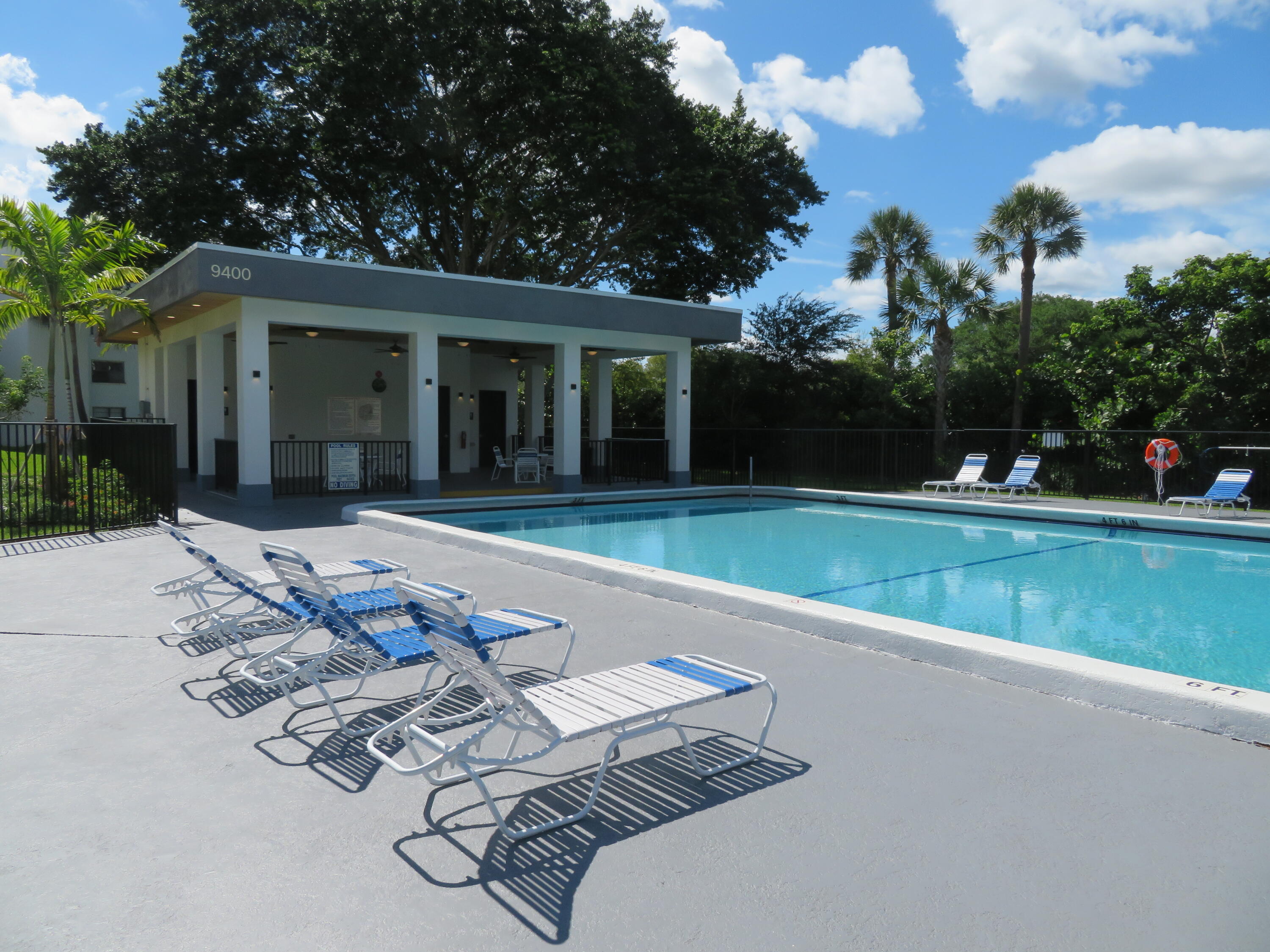 9233 Southwest 8th Street, Unit 117 Boca Raton, FL 33428 - Photo 21 of 37 a view of a house with a swimming pool and a yard