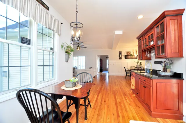 a view of a dining room with furniture a chandelier and wooden floor