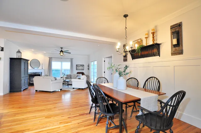 a view of dining room and livingroom with furniture wooden floor a chandelier