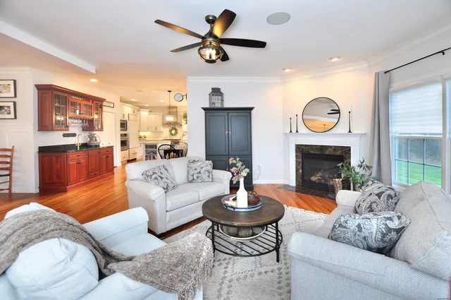 a living room with furniture a fireplace and a large window