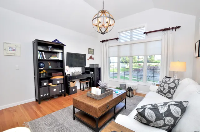 a living room with furniture a window and a flat screen tv