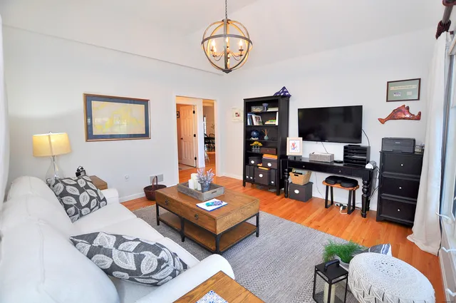 a living room with furniture a rug and a flat screen tv
