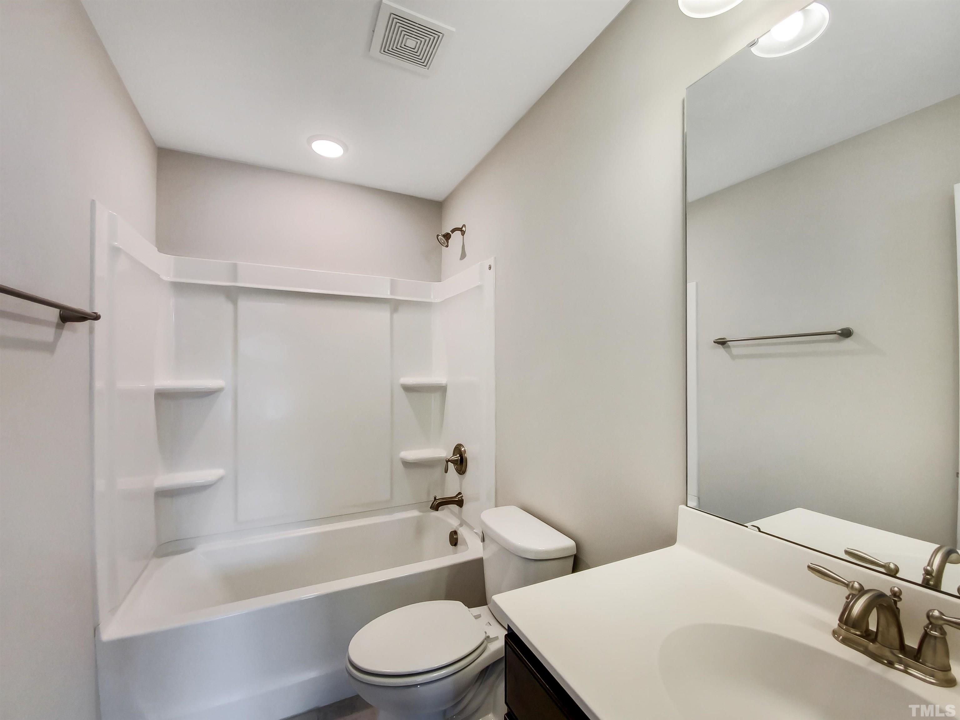 7006 Reedybrook Crossing Apex, NC 27523 - Photo 15 of 18 a bathroom with a toilet a sink and bathtub