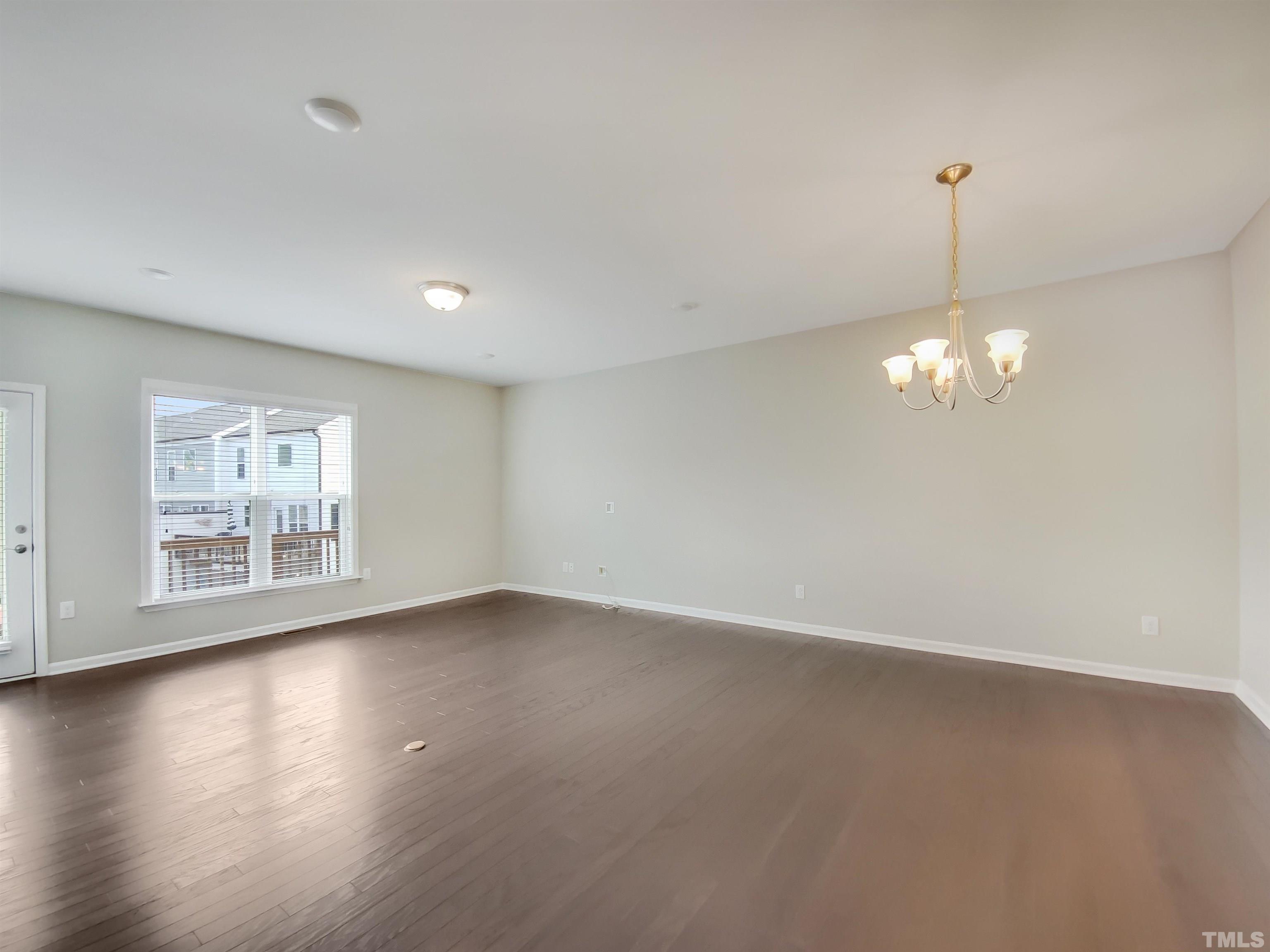 7006 Reedybrook Crossing Apex, NC 27523 - Photo 8 of 18 a view of an empty room with a window and wooden floor