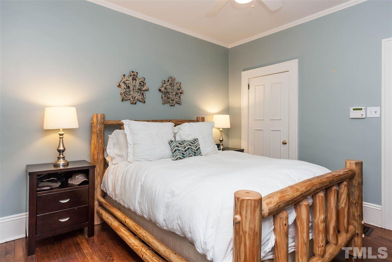 105 West Whitaker Mill Road Raleigh, NC 27608 - Photo 15 of 20 a bedroom with a bed and a lamp