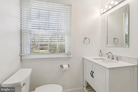 a bathroom with a sink a toilet and a mirror