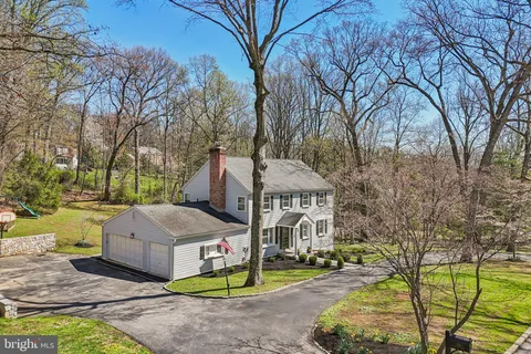 a aerial view of a house with garden and tall trees