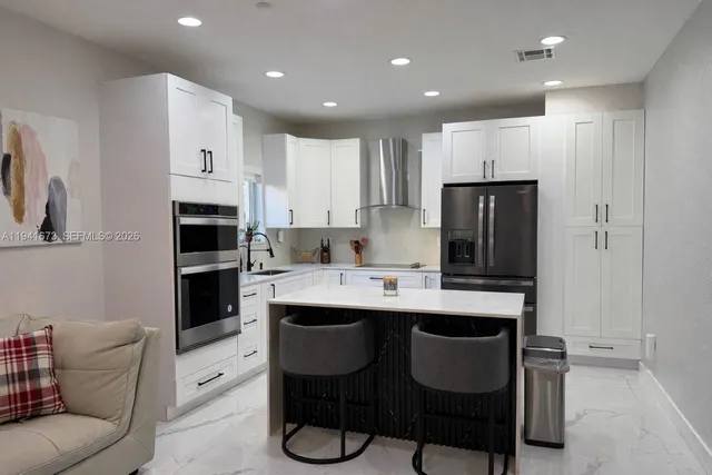 a kitchen with white cabinets and a stove with a sink