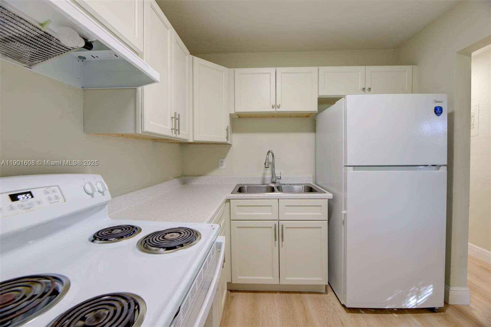 1880 Northwest 59th Way Sunrise, FL 33313 - Photo 12 of 27 a kitchen with a refrigerator stove and white cabinets