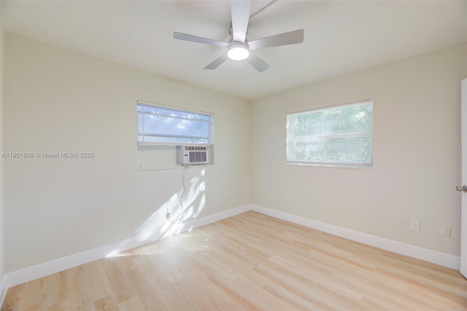 1880 Northwest 59th Way Sunrise, FL 33313 - Photo 14 of 27 a view of a room with wooden floor and a ceiling fan
