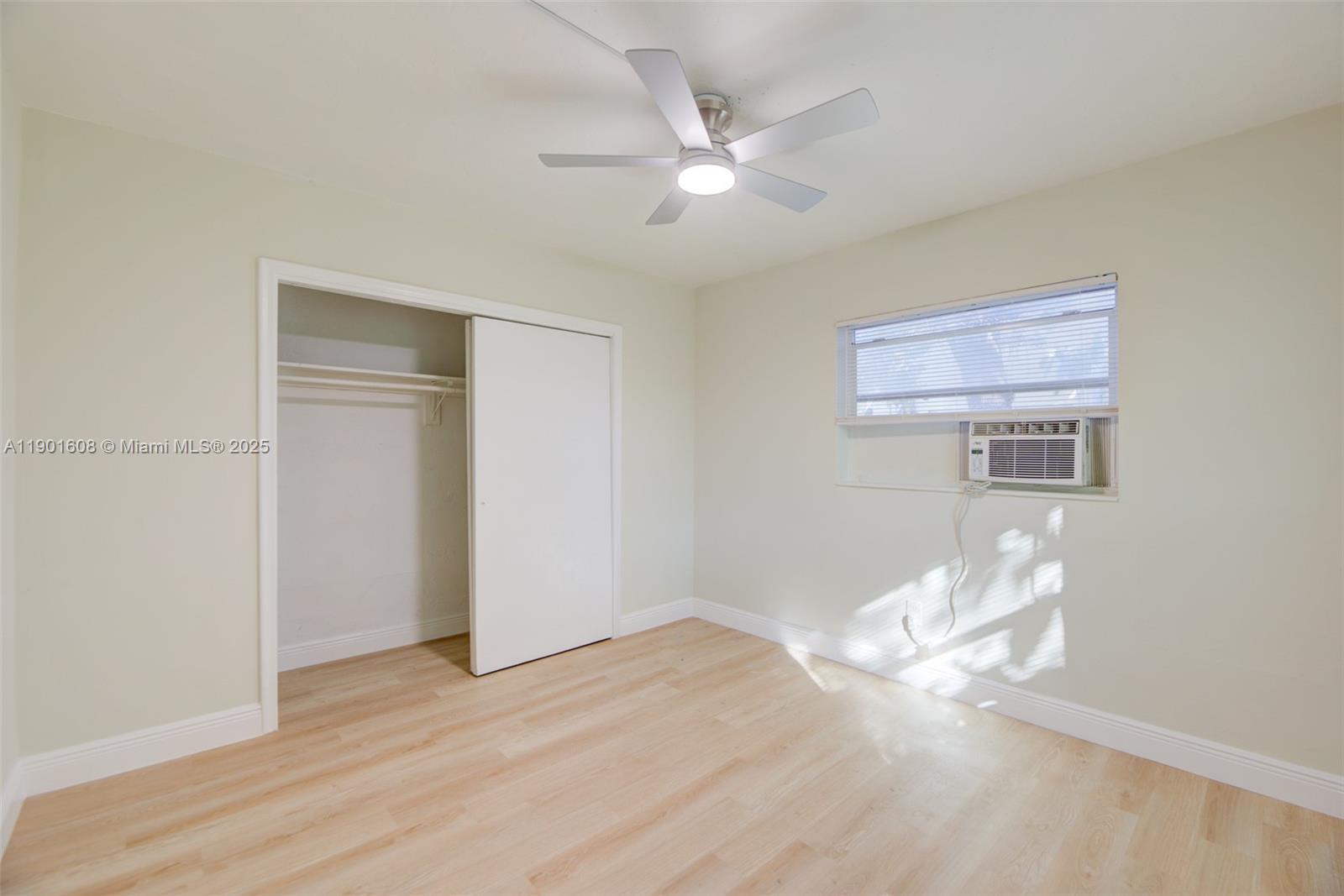 1880 Northwest 59th Way Sunrise, FL 33313 - Photo 17 of 27 a view of a room with wooden floor and ceiling fan