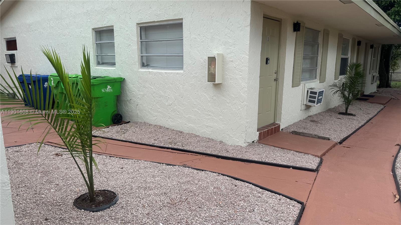 1880 Northwest 59th Way Sunrise, FL 33313 - Photo 26 of 27 a potted plant sitting in front of a house